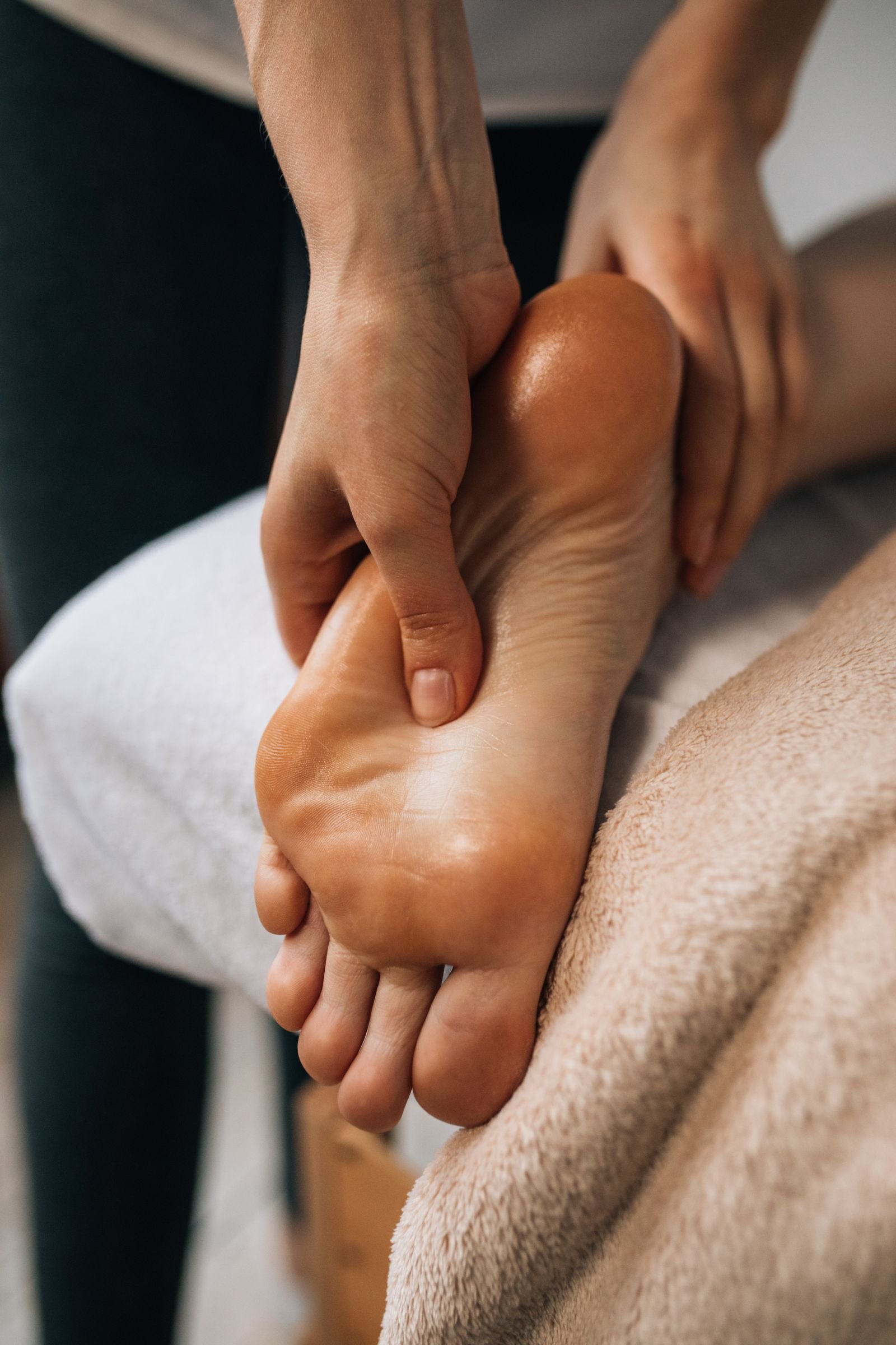 Hands massaging the sole of a client's foot