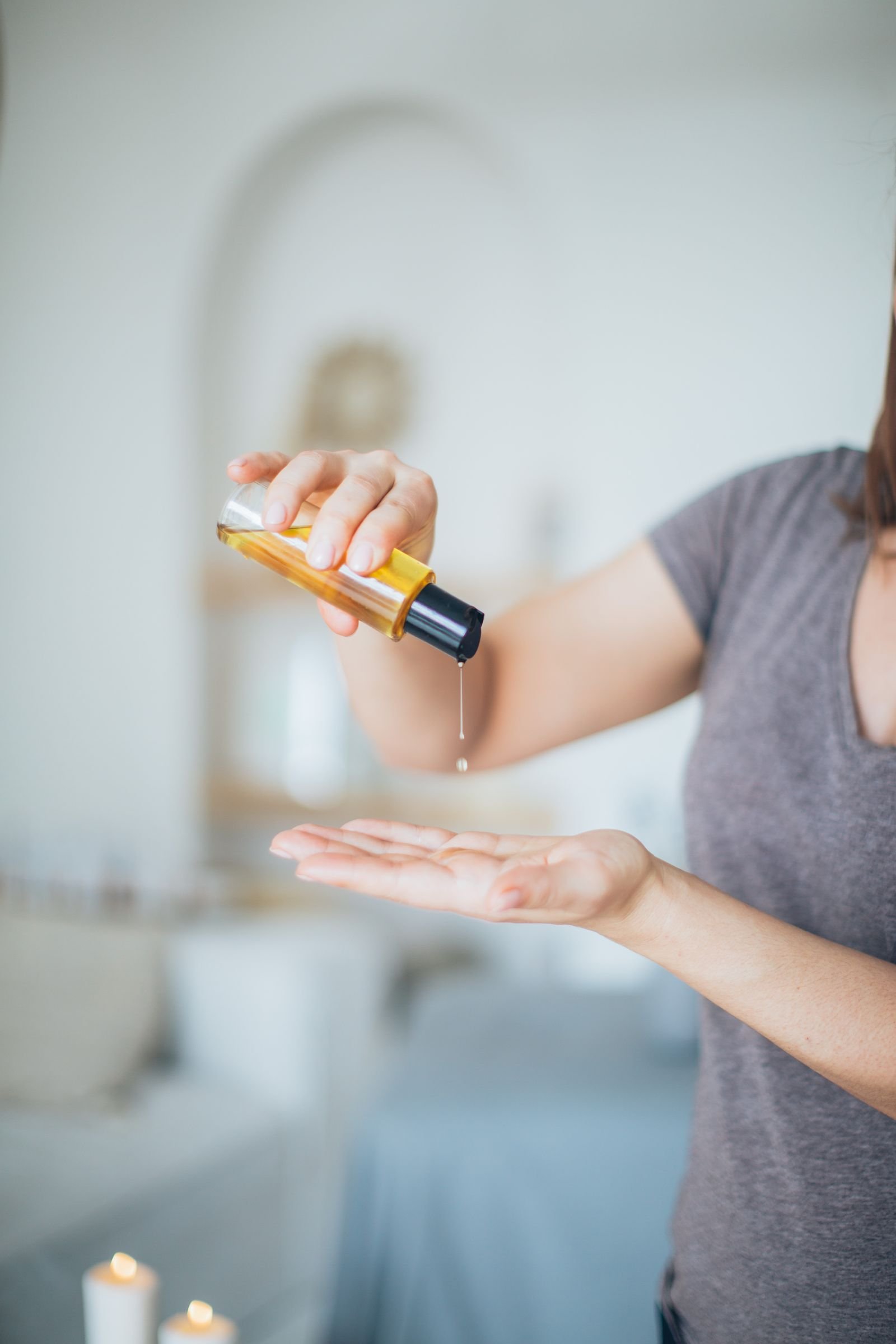 Gold shimmer massage oil poured into a hand