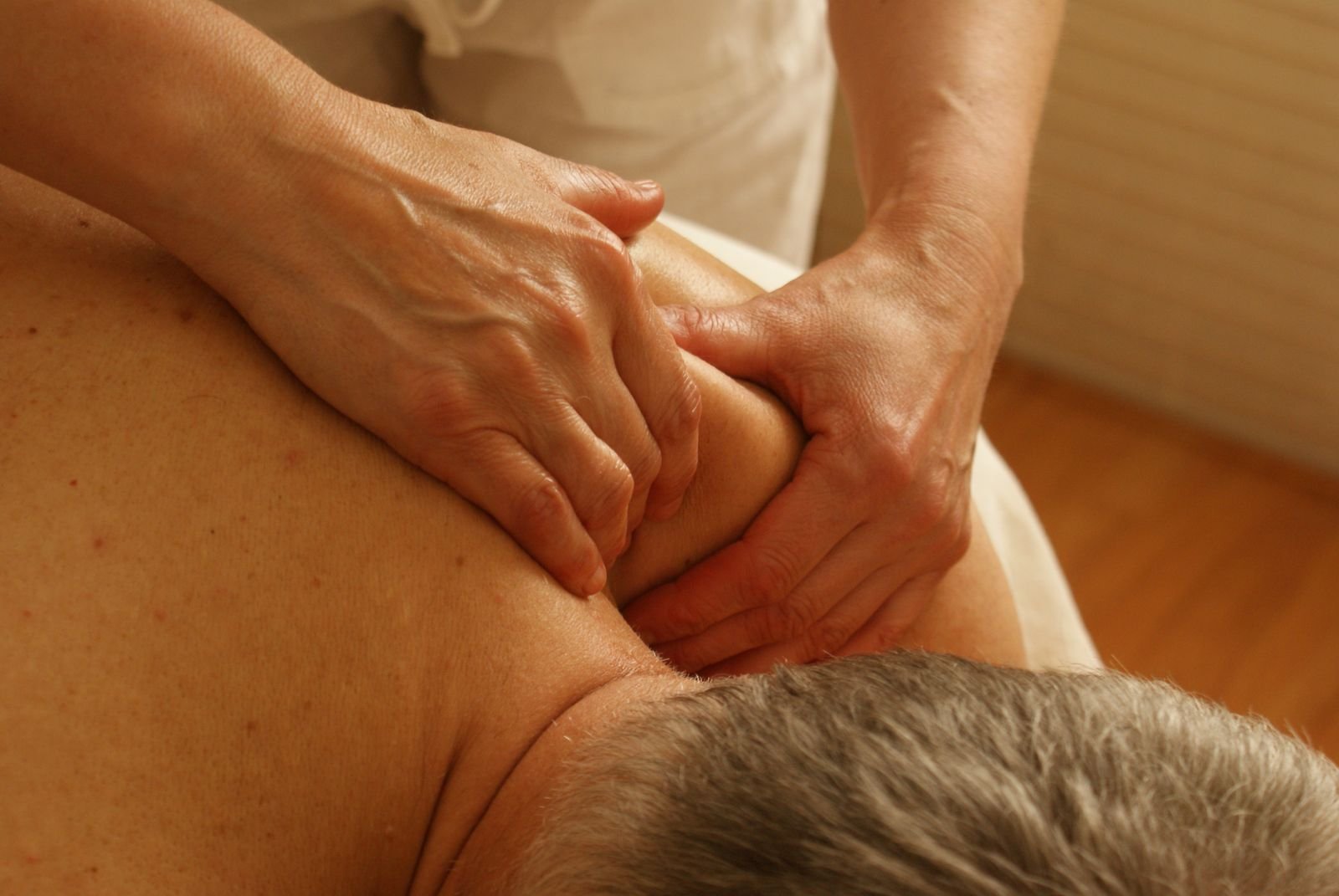 Hands massaging a client's neck and shoulder