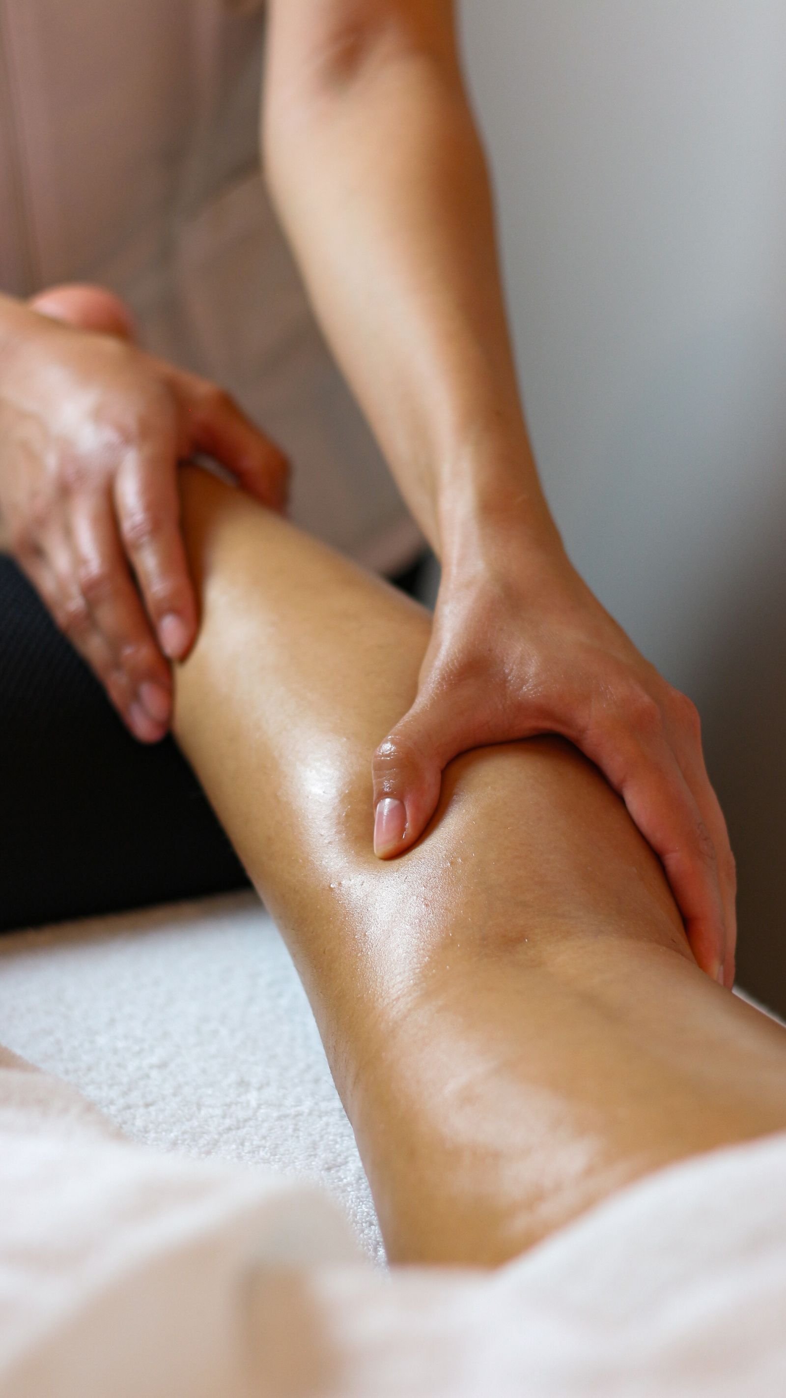 Hands massaging a client during a recovery massage session